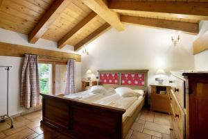 a bedroom with a large bed in a room with wooden ceilings at Au Petit Chevrot - Garden in Aosta