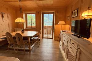 a dining room with a table and a tv at Valentin36 Apartment Geisler in Funes
