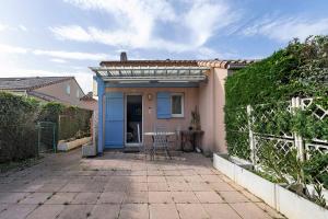 a small house with a blue door and a patio at M112 - L'orée Du Golf in Pornic