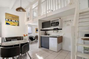 a kitchen and living room with a table and chairs at M112 - L'orée Du Golf in Pornic