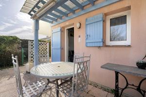 a patio with a table and chairs on a porch at M112 - L'orée Du Golf in Pornic +12 photos
