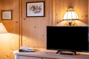 a flat screen tv sitting on a table next to a lamp at Valentin36 Apartment Geisler in Funes