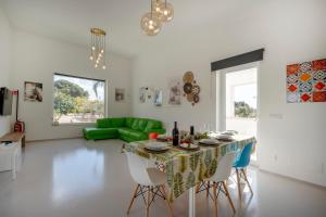 a living room with a table and a green couch at Villa Nilde in Triggianello
