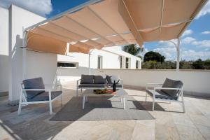 a patio with a table and chairs under a large umbrella at Villa Nilde in Triggianello