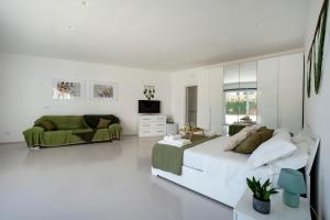 a white bedroom with a large bed and a couch at Villa Nilde in Triggianello +36 photos