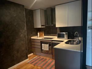 a kitchen with a sink and a stove top oven at Samitier in Cambrils