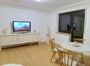 a living room with a television on a white dresser at Ferienwohnung Wandersnest in Gersfeld