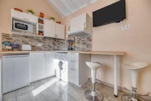 a kitchen with white cabinets and a tv on the wall at Casa cerca de Marbella in Ojén +12 photos