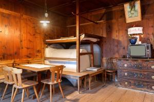 a room with a table and a bunk bed at Schloss Gravetsch in Villandro