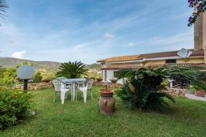 a patio with a table and chairs in a yard at Appartamento Chia Grande in Chia