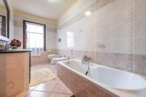 a bathroom with a tub and a toilet at Appartamento Chia Grande in Chia