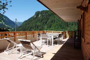 a patio with a table and chairs on a deck at Loges blanches b101 Roca immobilier in Châtel