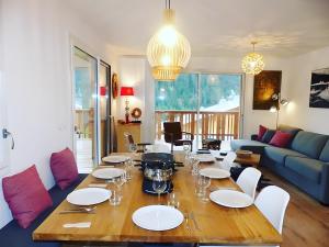 a living room with a table with plates and wine glasses at Loges blanches b101 Roca immobilier in Châtel +13 photos