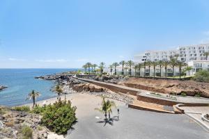 a view of a beach with palm trees and a building at 418 Panoramic View Playa Paraiso in Adeje