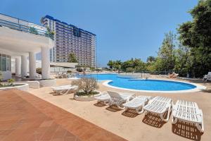 a group of white chairs and a swimming pool at 418 Panoramic View Playa Paraiso in Adeje