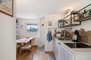 a kitchen with a sink and a table in a room at Tiny House zum See in Uhldingen-Mühlhofen