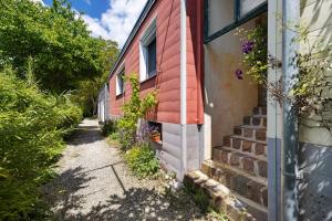 a brick house with flowers on the side of it at Tiny House zum See in Uhldingen-Mühlhofen