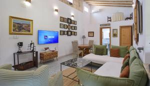 a living room with a couch and chairs and a tv at Valls in Montuiri