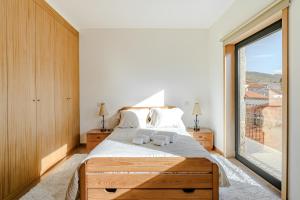 a bedroom with a bed and a large window at Casa Feixa Gerês in Geres