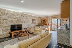 a living room with a stone wall at Casa Feixa Gerês in Geres