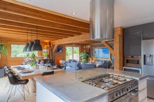 a kitchen and living room with a stove and a table at Chambre D'hôte au Chalet Datcha in Briançon
