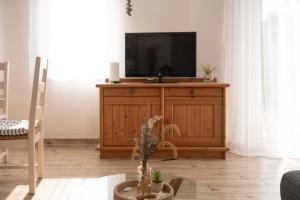 a living room with a television on a wooden cabinet at Bungalow Spinnaker in Ueckermünde