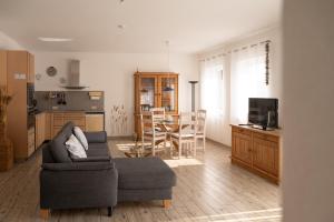 a living room with a couch and a kitchen at Bungalow Spinnaker in Ueckermünde