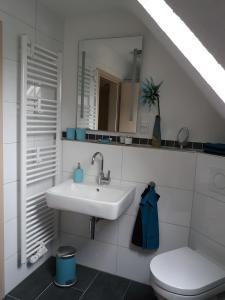 a white bathroom with a sink and a toilet at Haus Maruna in Schauenburg +25 photos