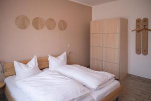 a bedroom with a bed with white sheets and pillows at Bungalow Spinnaker in Ueckermünde +23 photos