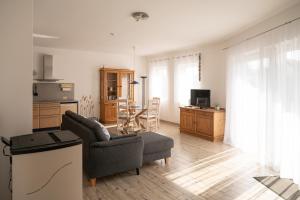 a living room with a couch and a table and a kitchen at Bungalow Spinnaker in Ueckermünde