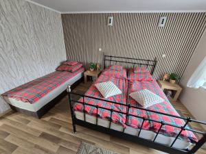 a bedroom with two beds with red and blue blankets at Dom wypoczynkowy Radomno in Radomno +24 photos