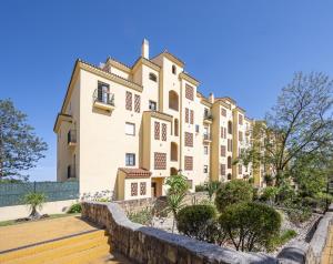 a large building with trees in front of it at Apartamento Las Joyas in Estepona
