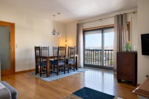 a dining room with a table and chairs and a balcony at Wander Unwind - Wine Cellars in Vila Nova de Gaia