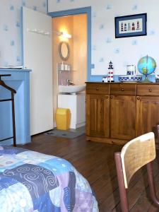 a room with a bed and a bathroom with a sink at Les Flots Bleus Cancale in Cancale +2 photos
