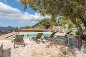 a pool with chairs and a table and a tree at Casa Roca Esporles in Esporlas