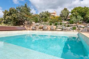 a large swimming pool with blue water at Casa Roca Esporles in Esporlas