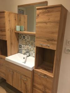 a bathroom with a sink and a wooden cabinet at Papi Stop in Villarlurin
