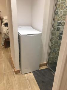 a small white refrigerator in a room with a shower at Papi Stop in Villarlurin