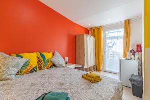 a bedroom with an orange wall and a bed at La Dolce Vita 2 in Lambesc