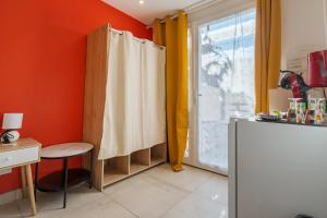 a kitchen with orange walls and a table and a window at La Dolce Vita 2 in Lambesc