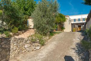 a gravel road with trees and a building at La Dolce Vita 2 in Lambesc