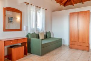 a living room with a green chair and a desk at Chroma Finikounda 2 in Finikounta