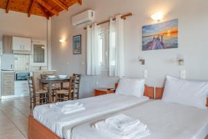 a bedroom with a bed and a kitchen with a table at Chroma Finikounda 2 in Finikounta