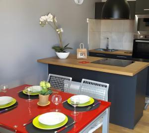 a kitchen with a red table with plates and wine glasses at Le Bellavista T2 Cassis Emplacement in Cassis