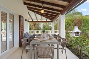 an outdoor dining room with a table and chairs at Casa Baskings in Portopetro