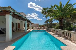 a swimming pool in the backyard of a house with palm trees at Casa Baskings in Portopetro