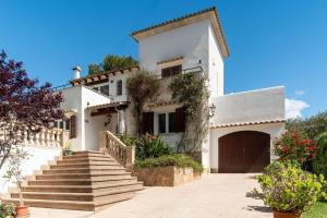 a white house with stairs in front of it at Casa Baskings in Portopetro