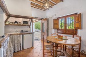 a kitchen with a wooden table and a small table with chairs at El Cobertizo in La Zubia