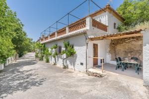 an external view of a house with a table and chairs at El Cobertizo in La Zubia