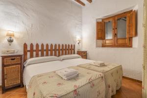 a bedroom with a bed with two towels on it at El Cobertizo in La Zubia +19 photos